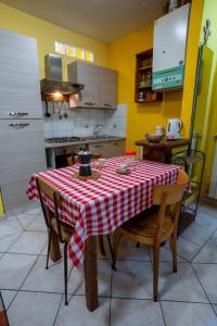 a kitchen with a table with a red and white checkered table cloth at The Hamlet and the Valley, Il Paesino e la Vallata in Foiano della Chiana