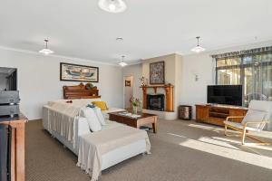 a large living room with a bed and a tv at Selmes Sanctuary - Blenheim Holiday Home in Blenheim
