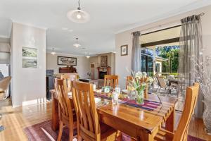 a dining room and living room with a wooden table and chairs at Selmes Sanctuary - Blenheim Holiday Home in Blenheim