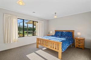 a bedroom with a bed and a window at Selmes Sanctuary - Blenheim Holiday Home in Blenheim