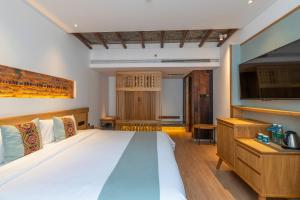 a bedroom with a large bed and a television at Yoba Boutique Hotel in Zhangjiajie