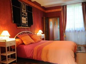 ein Schlafzimmer mit einem großen Bett mit orangefarbenen Wänden in der Unterkunft Guestroom Futeau, 1 pièce, 2 personnes - FR-1-585-112 in Futeau
