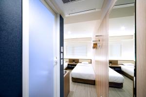 a bedroom with two beds and a window at Travelodge Kyoto Shijo Kawaramachi in Kyoto