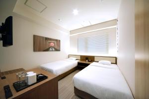 a hotel room with two beds and a window at Travelodge Kyoto Shijo Kawaramachi in Kyoto