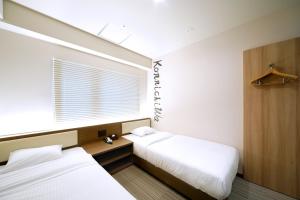 two beds in a small room with a window at Travelodge Kyoto Shijo Kawaramachi in Kyoto