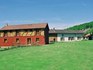 um grande celeiro vermelho com um campo verde à sua frente em Guestroom Futeau, 1 pièce, 2 personnes - FR-1-585-106 em Futeau