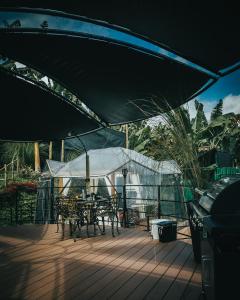 eine Terrasse mit einem Tisch und Stühlen unter einem Sonnenschirm in der Unterkunft Chamí Glamping in Manizales