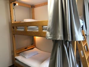 two bunk beds in a room with a curtain at SWELL in Hyuga