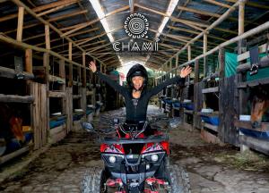 馬尼薩萊斯的住宿－Chamí Glamping，一位在谷仓骑四轮摩托车的女人