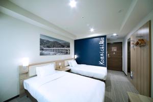 a hotel room with two beds and a blue wall at Travelodge Kyoto Shijo Kawaramachi in Kyoto
