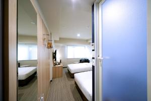 a hotel room with two beds and a mirror at Travelodge Kyoto Shijo Kawaramachi in Kyoto