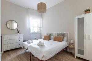 a bedroom with a white bed with two stuffed animals on it at Spacious and lovely in the City Center of Bilbao in Bilbao