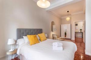 1 dormitorio con 1 cama blanca grande con almohadas amarillas en Spacious and lovely in the City Center of Bilbao en Bilbao