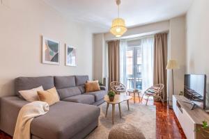 a living room with a couch and a tv at Spacious and lovely in the City Center of Bilbao in Bilbao