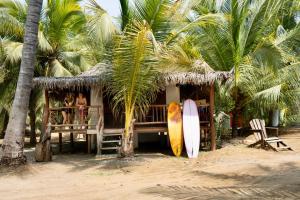 una casa en la playa con dos tablas de surf al lado en Los Bungalows de Blanca - Playa La Saladita, en La Majahua