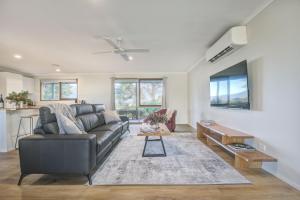 een woonkamer met een bank en een tafel bij Yering Park Cottage in Coldstream