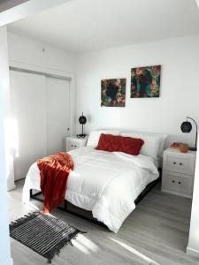um quarto branco com uma cama com um cobertor vermelho em Downtown Oakland Villa em Oakland