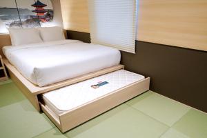 a small bedroom with a white bed and a window at Travelodge Kyoto Shijo Kawaramachi in Kyoto