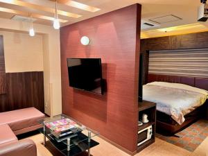 春日井市にあるHotel Opus -Adult only-のベッド、テレビ、ソファが備わる客室です。