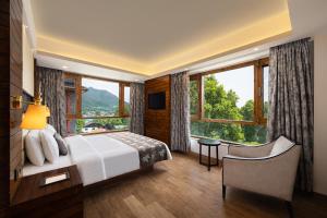 una camera da letto con un letto e una grande finestra di Golden Tulip Srinagar a Srinagar