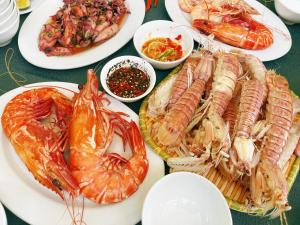 a table topped with plates of seafood and other foods at Quy Phuong - Homestay in Tân Hiệp