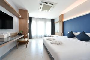 una camera d'albergo con un letto grande e una scrivania di VST Punnawithi a Bangkok Altre 36 foto