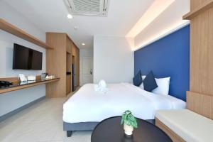 Habitación de hotel con 2 camas y mesa en VST Punnawithi - SHA Certified en Bangkok