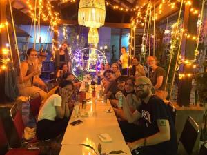 a group of people sitting around a long table in a restaurant at Quy Phuong - Homestay in Tân Hiệp