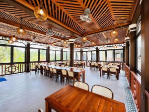 a dining room with tables and chairs and windows at Palm Bay Resort Phu Quoc in Phú Quốc