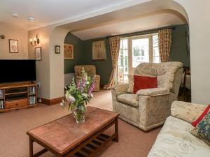 a living room with a couch and a table at Lower Court Byre in Kinsham