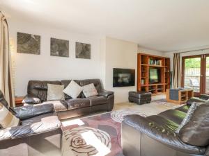 a living room with leather couches and a tv at Torestyn in Matlock