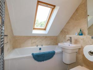 a bathroom with a bath tub and a sink at Torestyn in Matlock +21 photos
