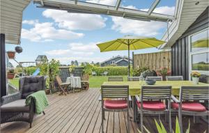 un patio con mesa, sillas y sombrilla en Beautiful Home In Rudkbing With 3 Bedrooms, Sauna And Wifi, en Spodsbjerg
