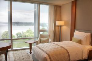 a hotel room with a bed and a large window at LOTTE Hotel Yangon in Yangon