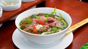 a bowl of soup on a plate on a table at Palm Bay Resort Phu Quoc in Phú Quốc