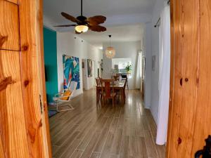 a dining room and living room with a ceiling fan at Casa Blanca Miramar in San Juan