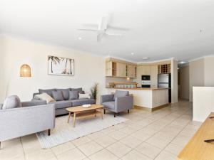 a living room with a couch and a table at Luna Sea Kingscliff with Ocean Glimpses in Kingscliff