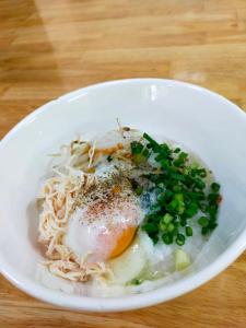 a bowl of noodles with an egg and green onions at Usagiyah Hotel & Guest House in Ho Chi Minh City