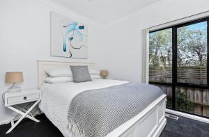una camera da letto bianca con un letto e una finestra di DashAway Inverloch a Inverloch