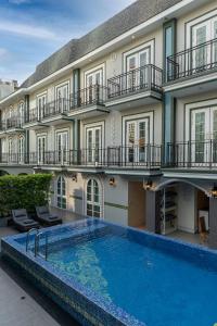 a hotel with a swimming pool in front of a building at La Petite Salil Sukhumvit Thonglor 1 in Bangkok