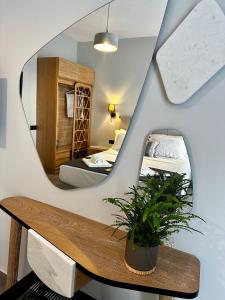 a room with a mirror and a table with a plant at Thea comfy living in Nea Vrasna
