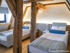 two beds in a room with wooden beams at Hotel Spichrz in Toruń