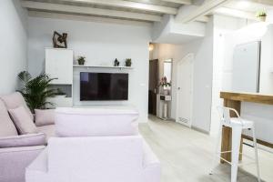 a living room with a purple couch and a tv at Elegante y acogedor. Buena ubicación in Osuna