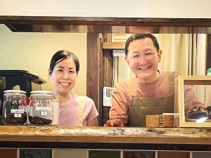 un hombre y una mujer de pie en una cocina en Guest House Pongyi, en Kanazawa