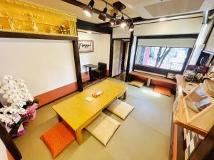 a living room with a wooden table and chairs at Guest House Pongyi in Kanazawa