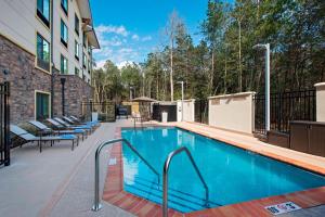 a swimming pool in a building with chairs around it at TownePlace Suites by Marriott Slidell in Slidell