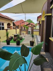a backyard with a swimming pool and plants at Rumah Cikgu 3bilik tidur in Jitra