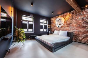 a bedroom with a bed and a brick wall at Chambers Roermond in Roermond