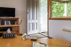 a living room with a table and a sliding glass door at JoY's Guesthouse in Romsey