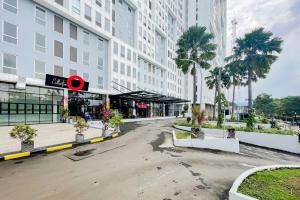 een lege straat voor een groot gebouw bij RedLiving Apartemen Patra Land Urbano - Happy Rooms Tower Mid-West with Netflix in Bekasi